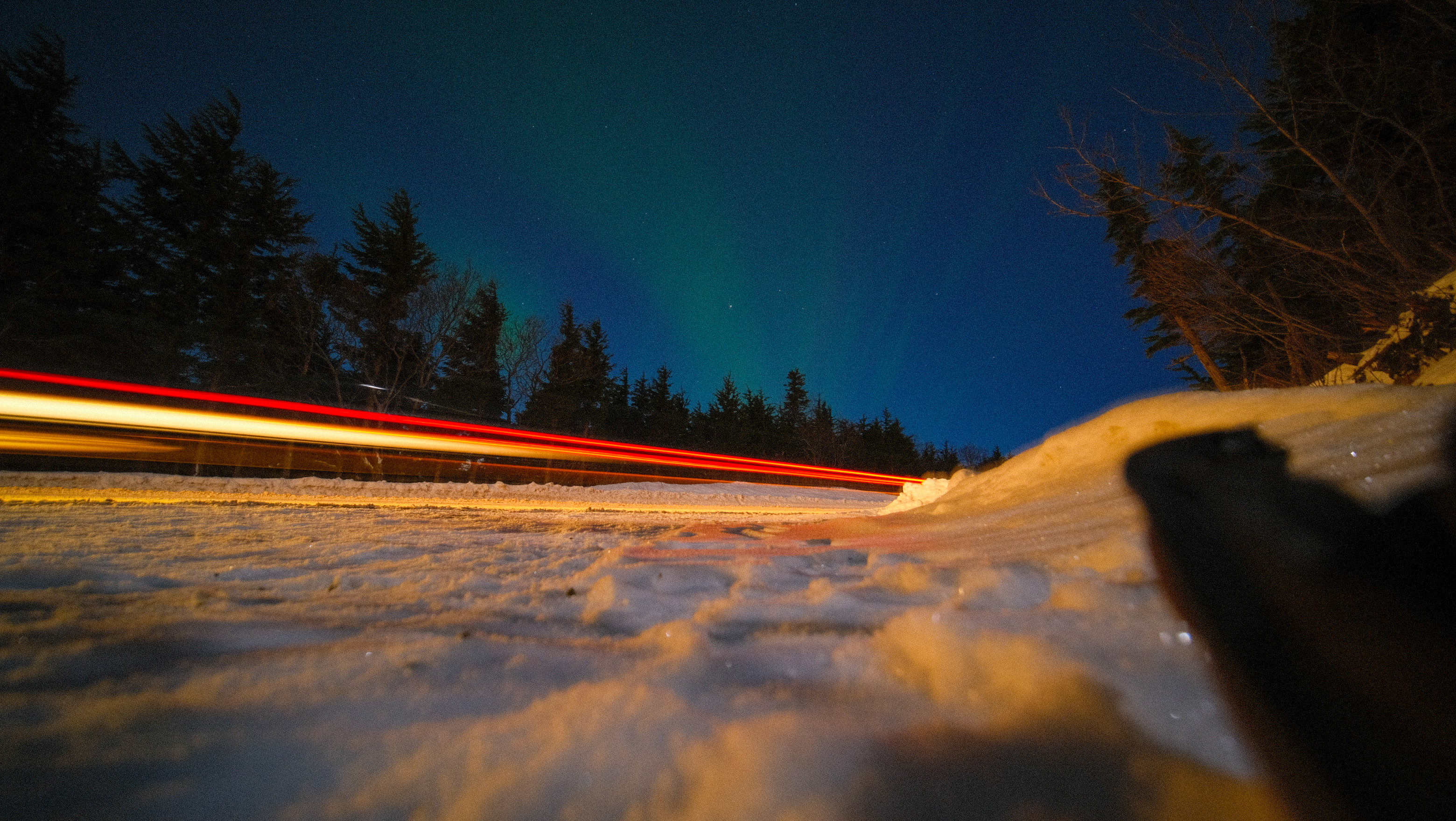 long exposure of car and aurora